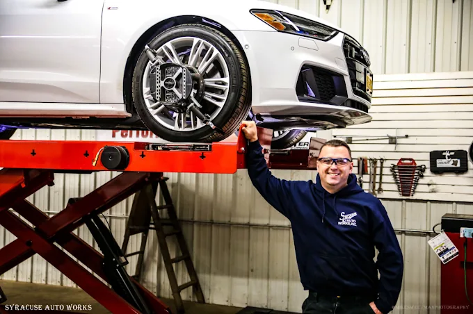 A car raised on the scissor lift in the alignment bay.