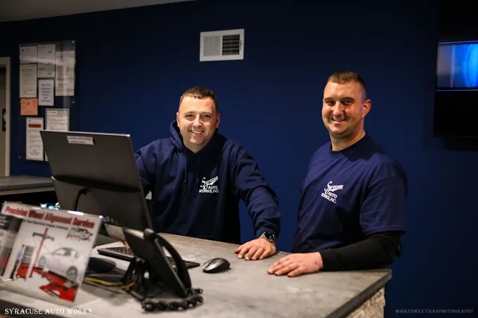 The Syracuse Auto Works service counter, with two staff members behind it.