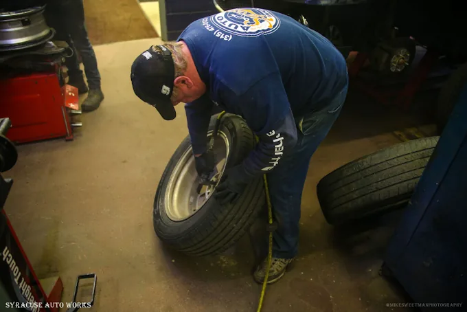 A technician mounting a tire in the tire bay.